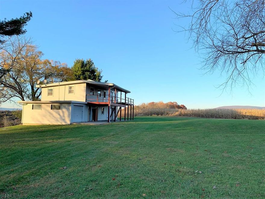 If you're looking for a private setting with rolling fields and mountain views, this is it!! Resting on 22.149 acres!! The home offers a living room, large kitchen with eat-in area and 1/2 bath on the main level. Second level has three bedrooms (one with its own deck access), a den/office and a full bath. One-car attached garage, 200-amp electric, heat pump with central air, a private well and private septic system. Huge second story deck great for enjoying those fantastic views. Land is mostly open with a small wooded area, 12' x 24' pavilion that's great for cookouts and entertaining, and a private gated driveway. Year-round living or a place just to get away from all the hustle and bustle!!