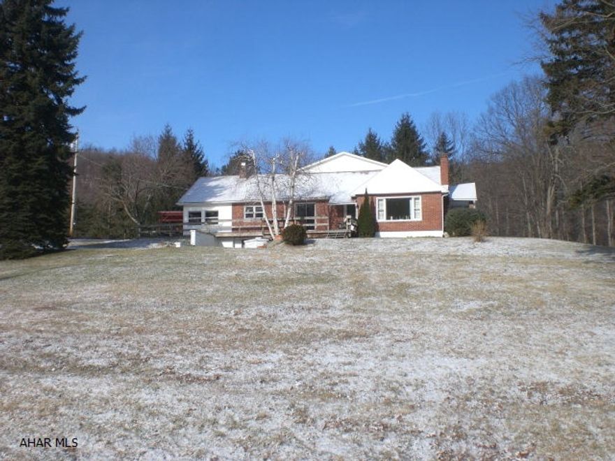 Spacious 1.5 story Brick home. LR w/wood FP, Kit w/oak cabinets, DA w/wood burner, Den, FR, 3 Beds, 2 Baths & Sun porch. Multiple heat sources, oil, wood or coal, you choose. Heated barn with workshop, garages & paint booth, storage building & picnic pavilion. 6.69 acres w/pond. Land is all open. Lots of possibilities w/thisproperty or could be a hobby farm.