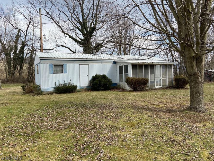 Small mobile home on a level lot of just under one acre backs up to farm fields. Close to the Sheetz Distribution Center. Could also be a nice spot to build a new home. Cash purchase only.