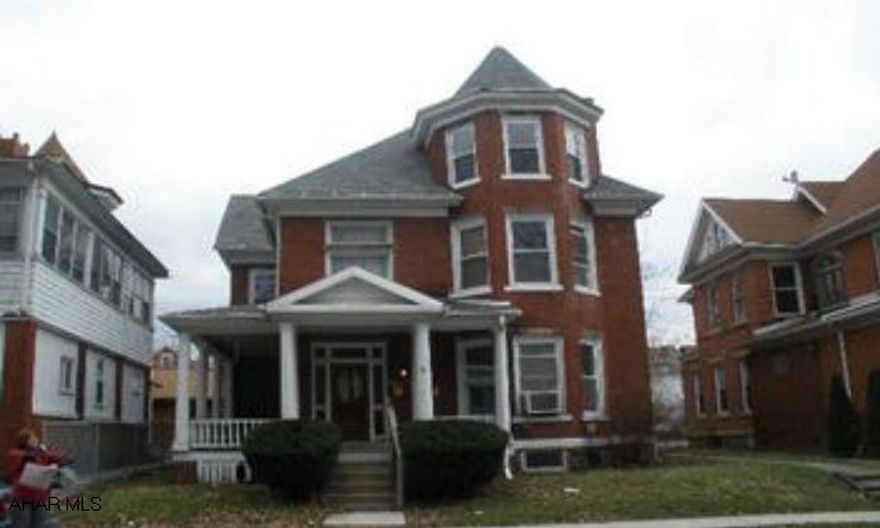 Brick triplex with off street parking.