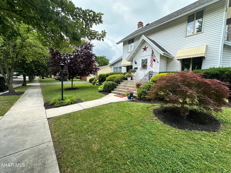 Classic traditional 3-5 bedroom home located on a tree lined street in Hollidaysburg Borough. This home offers hardwood floors on the main level. The painted stone gas fireplace adds a cozy touch to the living room. Enjoy the 3 season room with access to a rear deck area. There is a formal dining room with a built in buffet. This home has a new furnace and central AC system, electrical upgrades. New carpet on second level, brand new custom bath with subway tile and double sinks. 2 additional bedrooms could be used on the 3rd floor space. The backyard is fenced with white vinyl, also offers a paver patio and walk way to the 2 car detached garage. The landscaping is full of roses and many other plants to enjoy.