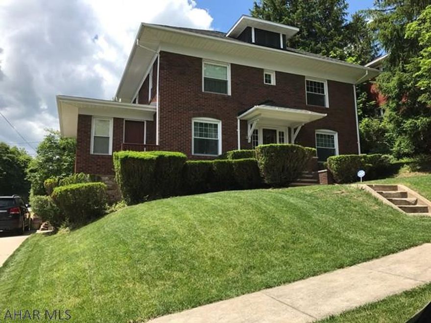 Charming Brick Beauty! Large 3 bed 2 bath with center foyer, leaded glass door and center staircase separates beautiful living room and formal dining room. Home sits in nice area not far from PSU Altoona Campus and UPMC Altoona Hospital on 50x120 corner lot with alley access. Public bus stops at corner.  First floor bath has large handicap shower. Kitchen and upstairs bath have glass tile wall and ceilings! Awesome sunroom off kitchen looks over patio and rear large rear lawn. Central Air, 1 car int garage, thermopane windows, hardwood floors under carpet upstairs, and more!  Must see this wonderful classic home!