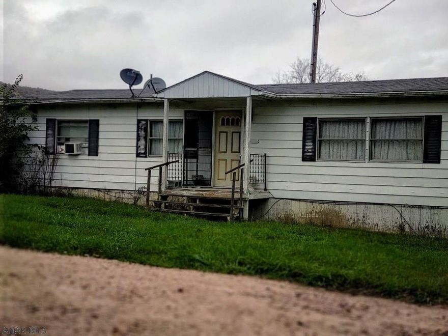 Enjoy the country setting! This property includes a double wide with 3 bedrooms, 1 and half bath, living room, dining and kitchen.  Nice size closets in each of the  bedrooms.  Master bedroom has  bath in it as well as a walk in closet.  It does need some TLC but could make a wonderful home.  Yard partially fenced.  Outbuildings on the property include a garage with a cement floor.  Finished pole building with a garage opener - tons of space to make a business in or to use for storage. Possibilities are really endless with this building and the property.  Another building on the property could be used for storage or livestock.  Property also includes another trailer site.  Close to State Game Lands