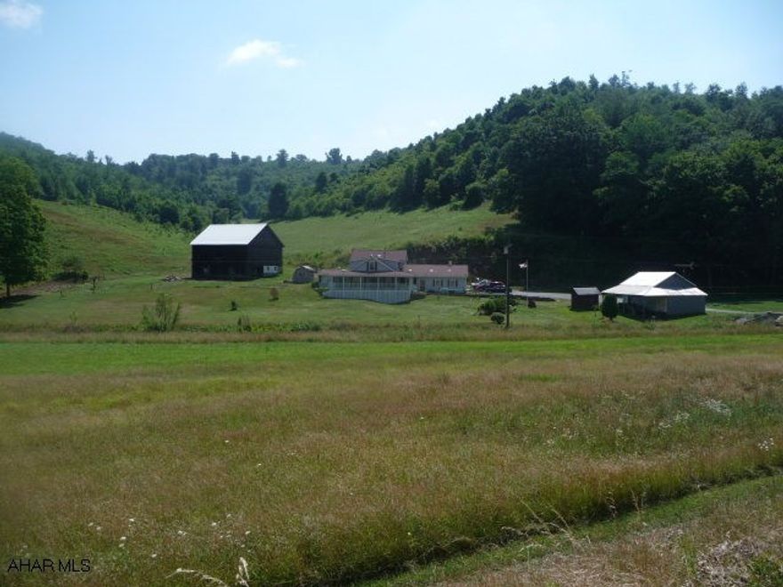 Spacious 3BR/2BA country home w/large wrap-around porch, on 58 acres in pleasant country setting. Spacious 3-car attached garage. Also includes 38x42 bank barn w/newer metal roof and four stalls for horses and a 18x38 work shop w/overhead door. Small stream across the front of the property. Home Warranty.