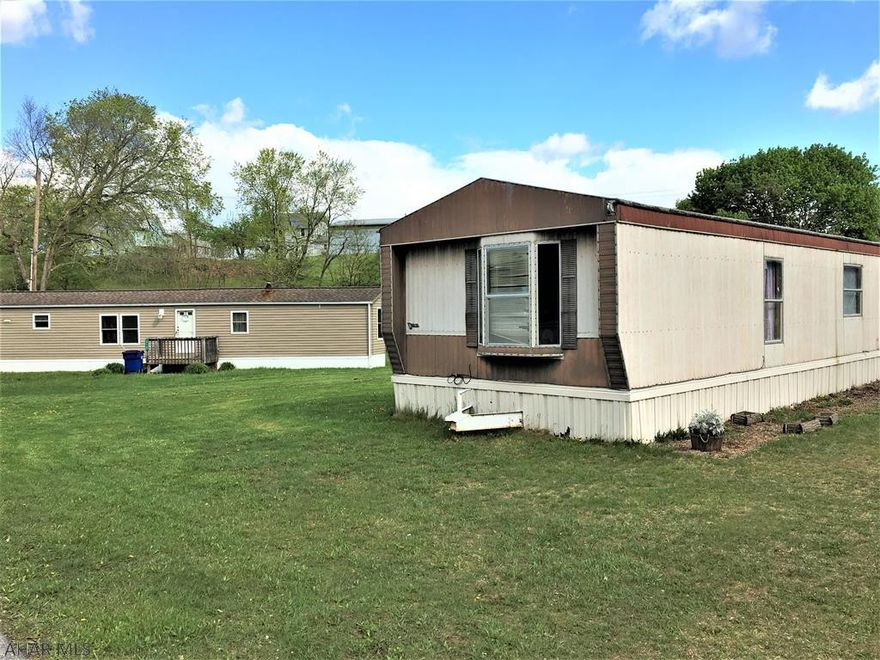 Calling all Investors! Land with well and public sewer, 1.4 acres. Currently has 2 singlewide mobile homes that provide a monthly rent. Mobile homes are NOT part of the sale , they are owned by the renters as well as the outbuildings. Land could have other uses if desired.