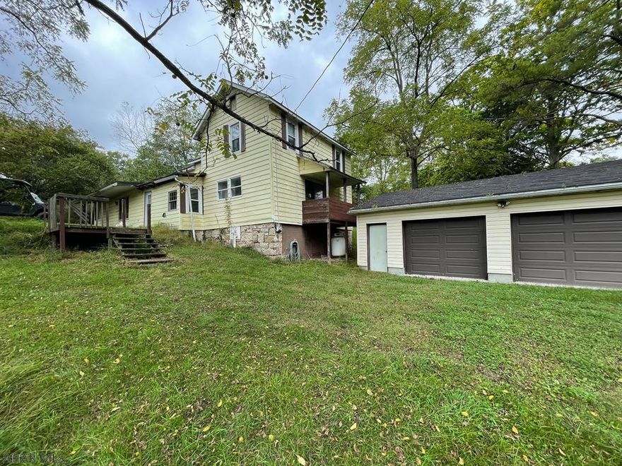 Surprise! Looks like a traditional house, but inside....it has the feel of a mountain retreat, with a great room, 2 sty fireplace, catwalk and loft.  The floors are a mix of hardwoods and pine while the kitchen is rustic with granite counters.  Bank Barn -  Running Spring (pond potential?) - Close to State Game Lands!  Hook-up for wood stove in garage.  Brand new house air conditioning unit and new propane furnace - both ready to be installed.  Yes, this house needs work to bring it to its full potential.  Do you have the vision to appreciate this unique property?