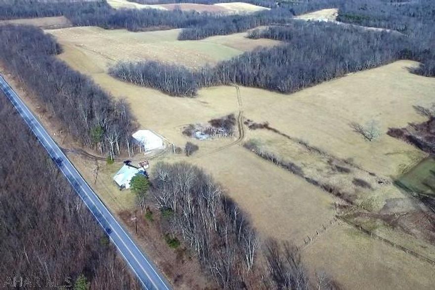 118.8+/- acres of rolling fields and woods, with pond, springs and seasonal stream. Includes 40'x60' pole barn, drilled/encased well and an old abandoned 1 1/2 story cinder-block house in need of full renovation. Beautiful country setting with awesome scenic views -last used for corn and hay production. Located 4 miles south of town with full west-side road frontage. Property is in the Clean & Green Program ad open for many agricultural uses. Property being sold AS-IS.