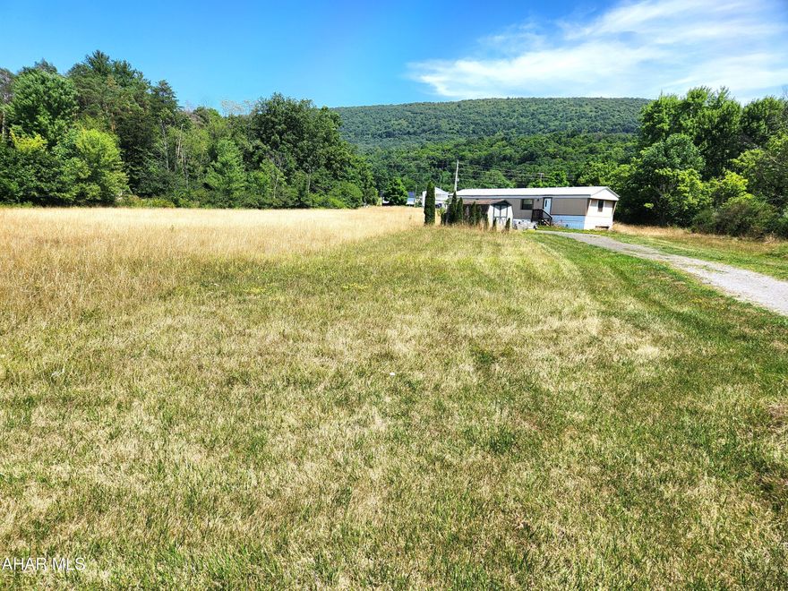 Are you looking for a building site, an investment property or home sweet home? This 3.25 acre gently sloping parcel may be just what you are looking for.  With mostly open land that has public water, public sewer, electricity and a single-wide trailer, this may be the property for you.  With some TLC, the home could be used for your residence or as a rental unit.  Remove the mobile home, and you'd have a wonderful building lot for your dream home.  Come and take a look, it may be just what you're looking for!