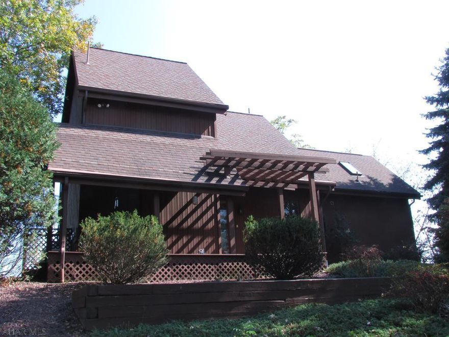 Incredible view of Lake Raystown!  Chalet on 1.6 acres. Great for a residence or vacation rental - has divided areas of first floor master w/bath & loft; 2nd floor master w/bedroom; lower level.  Paved circular driveway & great outdoor design. Large covered front porch and 3-tier deck at back w/views. Generator. Two hot water heaters - one for 2nd master suite. Central Vac. Large shed/storage area. Elegant mixed with lake look - fireplace between great views of the lake, hardwood floors, loft, wood on some ceilings and walls, beams, skylights, open & spiral staircase.  Lower level is partially finished - has wiring and insulation, woodstove is included but not installed.  Wooded on both sides of property so semi-private. Lots of wildlife sightings. 5 minutes to Shy Beaver launch.