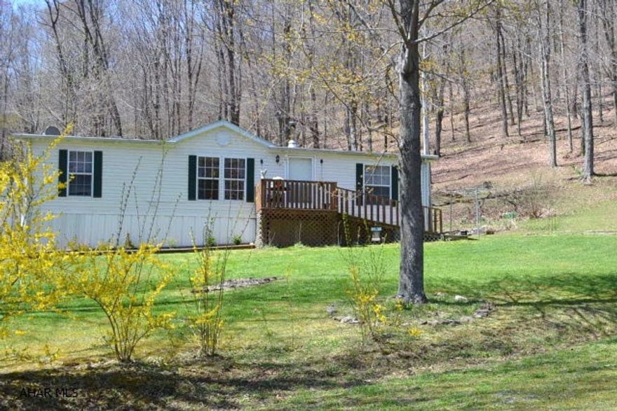 Enjoy the best of secluded country living in this 2001 Marlette manufactured home sitting on 3.1 mostly wooded acres featuring 3 bedrooms, 2 full baths and a large open country kitchen.  Included is a 2-car detached oversized garage (36' by 36') and an adjoined 10' by 26' workshop/garage.  Once you cross over the creek at the entrance to the property you'll find many wooded and grass/yard areas as well as many different gardens including herbs and butterfly.  The extended deck area with cement slab and electrical hook-up for outdoor Jacuzzi features outdoor LED pathway lighting.  Unwind in the hammock before heading out to the Poplar Run stocked trout stream within 3 miles.  And outdoor people will only travel 8 miles to Blue Knob ski resort and state park or 10 miles to state game lands.