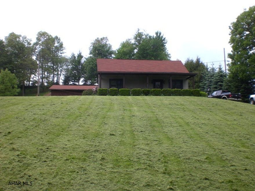 1.5 story log built home w/ vinyl siding. Great rm w/ cathedral ceiling, kitchen w/ knotty pine cabinets, den, 2 BR and 1 BA. Full walk out bsmt, oil HW heat, 100-amp electric & 2-car detached garage. Front covered porch, thermo pane windows & a great view of the countryside. 1.55 acre lot in a nice country location.