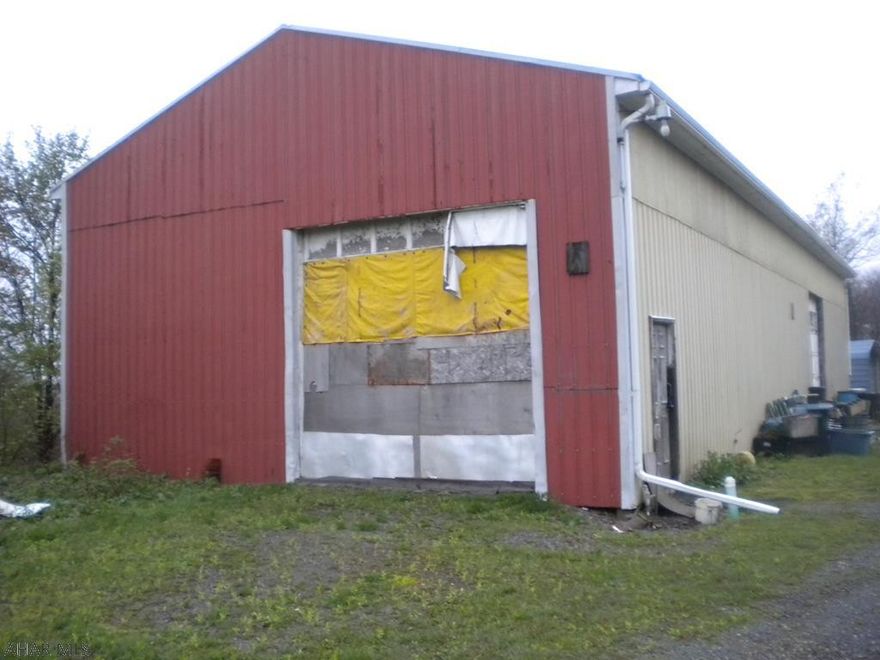 Metal storage building 32x80 with Two 12x12 Overhead Garage doors.   Situated on 3.5 acres. Current owner had water & sewer ran to property. The natural  gas line is ran to the property also. And electric. This property could be used for many opportunities including a garage, storage units or a warehouse. There is a single wide trailer on the property that is not livable. Car port at back of the building is not included in the sale of the property.