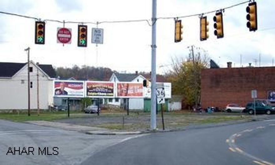 Irregular shaped corner parcel containing 4 contiguous lots. Large strategic corner location. Large property with many possibilities. Bring offers!