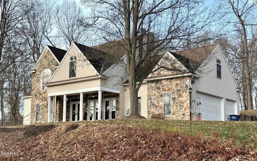 This beautifully designed four-bedroom, 3.5-bath home showcases quality workmanship throughout and is ideally located in the well-established and highly sought-after Juniata Mills neighborhood of Bedford County, within the desirable Bedford Area School District.

 From the moment you enter, it's clear this home was thoughtfully built with attention to detail, comfort, and lasting quality. Captivating mountain views and incredible floor-to-ceiling windows fill the home with natural light and frame the surrounding countryside.

The main level features rich Brazilian walnut hardwood floors and a stunning living room with soaring cathedral ceilings. A dramatic transom window highlights breathtaking mountain vistas, while a floor-to-ceiling window on the opposite side overlooks the pool and outdoor entertaining area. An open staircase and upper-level overlook enhance the airy, architectural appeal of the space. 

The flexible floor plan offers exceptional versatility, with a dining room that could easily be enclosed to create a beautiful main-floor primary suite, while an additional nearby room can comfortably serve as a formal dining area.

The large, well-appointed kitchen is both inviting and functional, featuring granite countertops, abundant cabinetry, and generous storage, making meal preparation effortless and enjoyable. The kitchen opens seamlessly to a lovely deck with a pavilion and pool beyond—ideal for cooking while keeping an eye on the kids in the pool or hosting memorable gatherings. 

The pool itself is thoughtfully designed for fun and interaction, featuring shallow ends on both sides, making it perfect for games such as water volleyball, casual play, or relaxing with friends and family.
A main-floor laundry room conveniently located just off the kitchen adds everyday ease. 

The bedroom layout includes a thoughtfully designed Jack-and-Jill bath shared by two bedrooms, offering both convenience and privacy, while the remaining bedrooms are generously sized. Upstairs, the expansive primary suite is a true retreat with cathedral ceilings, a spacious ensuite bath with dual vanities, and two walk-in closets.

The lower level offers a very large game or recreation room, perfect for entertaining, hobbies, fitness space, or movie nights. Completing the home is a three-car garage, providing ample space for vehicles, storage, and recreational equipment.

With its exceptional craftsmanship, breathtaking views, and versatile living spaces, this remarkable home delivers an outstanding lifestyle opportunity in Bedford County's Juniata Mills community.