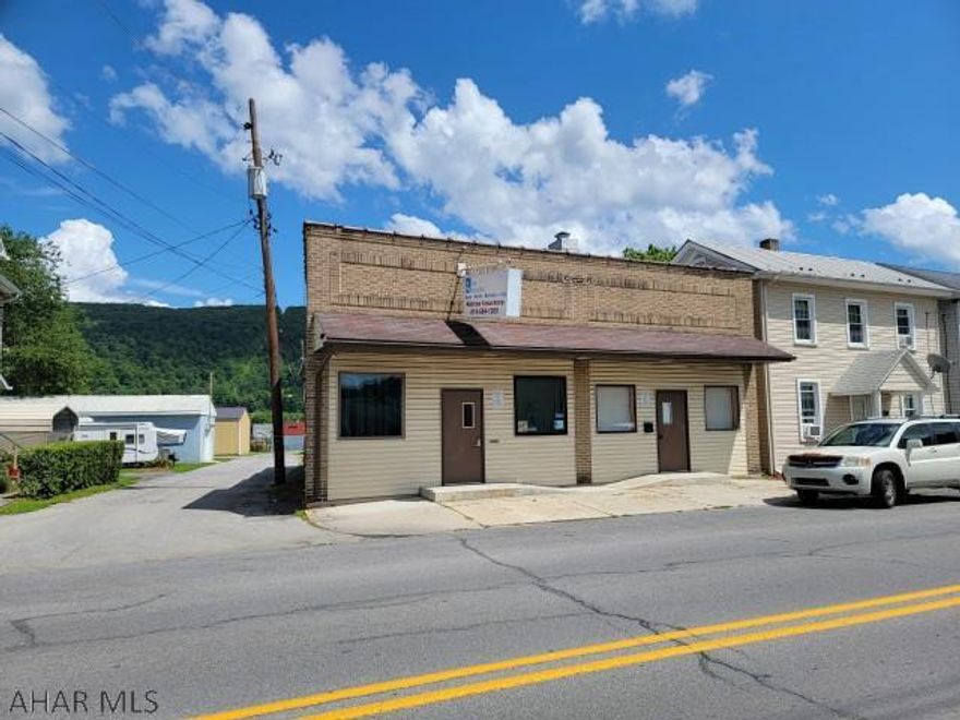 Two commercial offices with 40'  x 75' block garage/warehouse. One office is presently being used as a studio apartment. Other was previously used as an insurance office with reception area/office, 3 private offices, a kitchen, records room and a 1/2 bath. There are 2 gas forced air furnaces and 2 electric panels, but utilities are not separated. Large garage/warehouse has several room partitioned off in the rear, but could easily be opened back up. Off street parking.