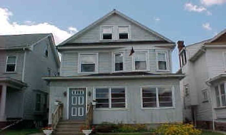 MUST SEE INSIDE! Very nice maple kitchen with cherry finish, large foyer, living room, dining room. Pine floors, new windows and newer furnace & C/A.  Finished attic with heat and C/A. 3 parking spaces in alley.