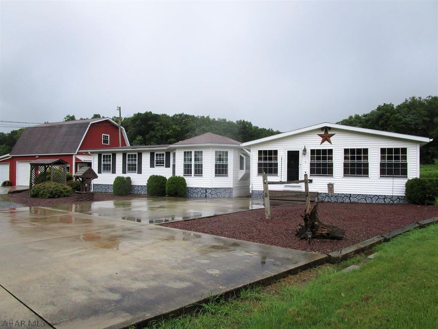 Very, very well-maintained, updated and upgraded one-story manufactured home!! So much to offer with one-story living; large sun room, living room, kitchen, dining room, den/office, 3-beds, rec room and 1.5 baths. Oil forced air, central air-conditioning, propane fireplace, well water and city sewer. Large three-car heated detached garage with a full finished loft above. Nice flat .99 acre lot with scenic views.