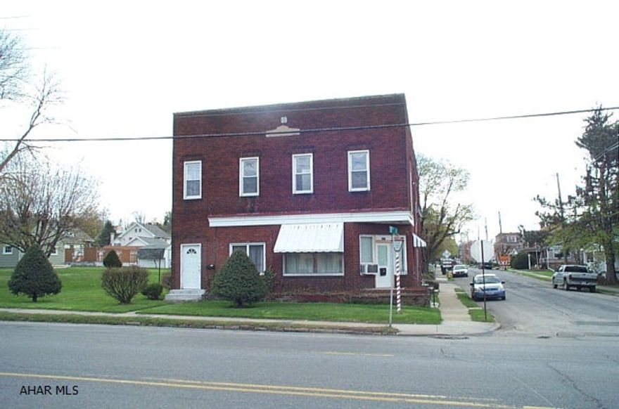 2 Story brick building with 4 car garage on 125 x 120 lot. Former barber shop and living quarters on first floor with 2 apartments above. Separate gas and electric.