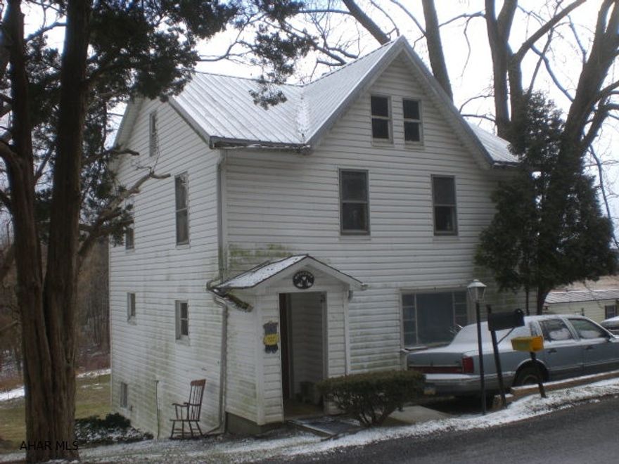 2-story house on 10.5 acres. Single-wide trailer on land but it is tenant owned. New sand mound septic system.  Land is split by road. House needs TLC. Tenants pay $450.00 a month for house and $250.00 for trailer lot rent.