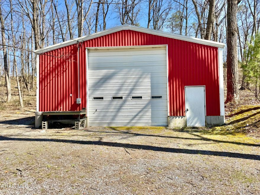 32'x57' garage featuring a 14'x14' overhead door, 16' high ceiling in the center, concrete floor, electric, and an oil-forced air furnace. This property would make a great place to open that small business that you've wanted to start or ample space to store and work on your hobbies. Also included in the sale is a rented mobile home with public water and sewer, offering extra income or living space. An adjacent 1600+ sqft home with 3 bedrooms and 1.5 baths is available to be purchased. AS-IS sale. Seller will make no repairs.
