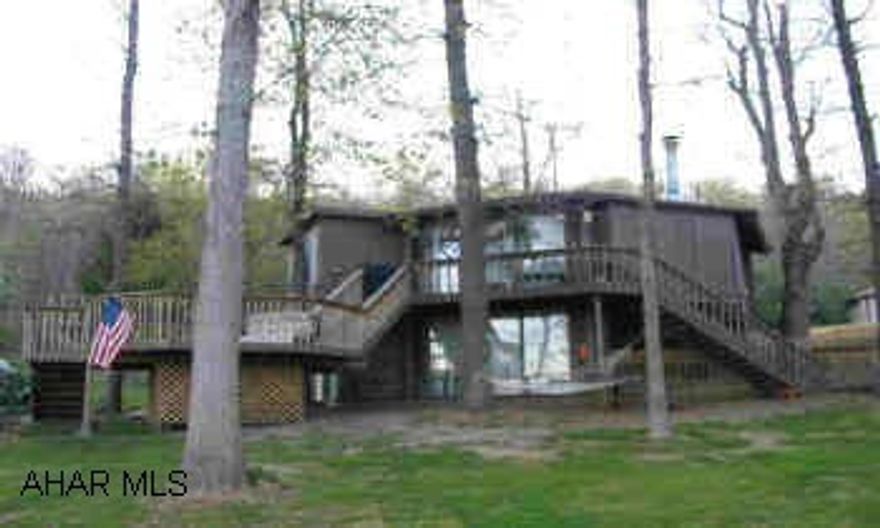 Contemporary octagon-shaped Topsider nestled in woods, overlooking Bedford Springs Golf Course. 3BR/2BA, open floorplan, wraparound deck with spectacular views of golf course and mountains.