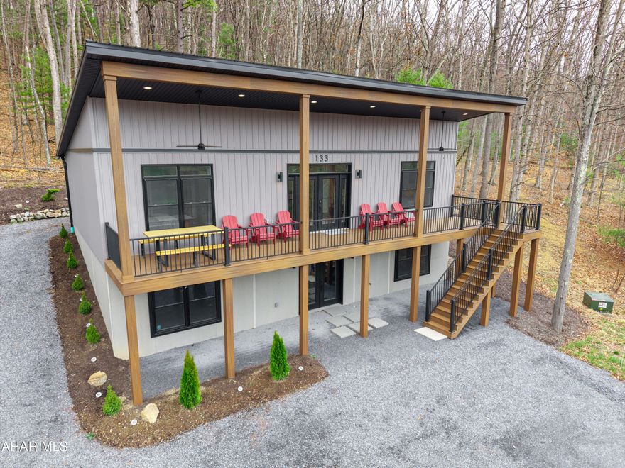 Prepare to be captivated by this gorgeous contemporary gem!! Nestled next to the lands of the renowned Omni Bedford Springs Resort and Golf Course, this newer build offers three bedrooms, two full bathrooms (including a primary suite), a large main floor laundry room, and an open concept living space ideal for modern lifestyles. Bright and airy kitchen with island, sleek quartz countertops, custom tile backsplash, and stainless-steel appliances, this space seamlessly flows into the great room that is perfect for entertaining or just cozying up and reading a book. The great room features a tapering 13' tall, vaulted ceiling and double doors leading to some absolutely beautiful views of the Springs Golf Course and Evitts Mountain. Step outside onto the massive 45' covered front porch with double ceilings fans and relax while soaking in the scenery. Maintenance free construction featuring Trex decking, vinyl siding, vinyl doors and windows and a metal roof. The recessed lighting throughout; elegant tiled showers; and solid core wood interior doors elevate the experience. The full, walkout-out basement is already studded presenting an incredible opportunity to easily create additional living space. Large, wooded lot, stone firepit that is perfect for smores and star gazing and a calming rear deck ready for grilling. Hiking and biking trails are just steps away. This is more than just a home, it's a lifestyle waiting to be discovered.