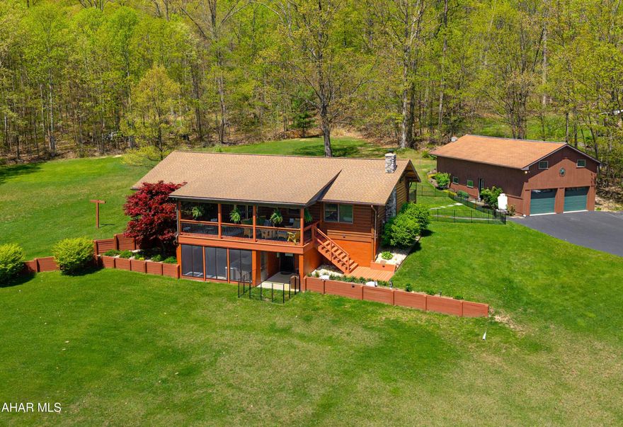 Rustic Charm Meets Modern Elegance on 10 Private Acres Near State Game Lands

Tucked away in one of the most peaceful, private settings imaginable, this beautifully renovated log home blends rustic character with modern luxury. Surrounded by 10 acres of serene natural beauty and just minutes from thousands of acres of state game lands, this home offers the perfect escape for nature lovers, outdoor enthusiasts, or those simply seeking a quiet retreat.

Enjoy your mornings on the lovely covered front porch, sipping coffee as the sun rises over lush, professionally landscaped grounds. In the evenings, retreat to the second covered porch that captures golden sunsets and overlooks a tranquil, fenced area—perfect for letting pets roam freely while deer and wild turkeys roam by.

Inside, the home features a floor-to-ceiling stone fireplace, solid-surface kitchen counters, double ovens, and a designer-inspired color scheme that elevates every detail. The shingled roof color was carefully chosen to enhance curb appeal, complementing the home's natural log exterior.

The huge master bedroom is a true sanctuary, offering a peaceful escape with room to unwind. It includes a walk-in closet you can only dream of—spacious, well-organized, and packed with storage solutions for every need.

The flexible lower level offers endless possibilities—create a fabulous entertainment space, a private guest suite, or a fully functional one-bedroom apartment with its own entrance. It also features one of the home's two brand-new bathrooms, with the second located upstairs.

Off the lower level is a screened-in porch, complete with a hot tub that overlooks the beautifully maintained yard—offering a private, peaceful space to relax while enjoying the surrounding nature. This area provides ideal separation for multi-generational living or guest accommodations.

A major highlight of the property is the huge, oversized heated garage—fully equipped with electricity and an impressive workshop space. The upper level of the garage offers private, drive-in access with its own separate entrance, perfect for storing equipment, lawn care tools, recreational vehicles, or transforming into additional workspace or storage.

This home is strategically located with quick access to I-99, Route 68 in Maryland, and the Pennsylvania Turnpike. It's also just minutes from Omni Bedford Springs, one of the region's most sought-after historic hotels, offering guests and locals access to the #1 public golf course in the United States and an award-winning luxury spa.

And beyond the home itself, the charm of historic Bedford County cannot be overstated. It is a place of deep heritage and welcoming beauty—majestic in its scenery and rich in small-town character, offering a timeless backdrop for a truly exceptional lifestyle.

Whether you're seeking a peaceful retreat, a multi-generational living solution, or simply a place where rustic charm meets modern comfort, this exceptional log home delivers it all. From its thoughtfully designed interior and flexible living spaces to its outdoor serenity and proximity to nature, recreation, and regional landmarks, every detail has been carefully curated to create a home that feels both luxurious and welcoming. Set against the backdrop of majestic Bedford County and just moments from one of the area's premier resorts, this property offers not just a home—but a lifestyle grounded in beauty, comfort, and timeless Appalachian charm.