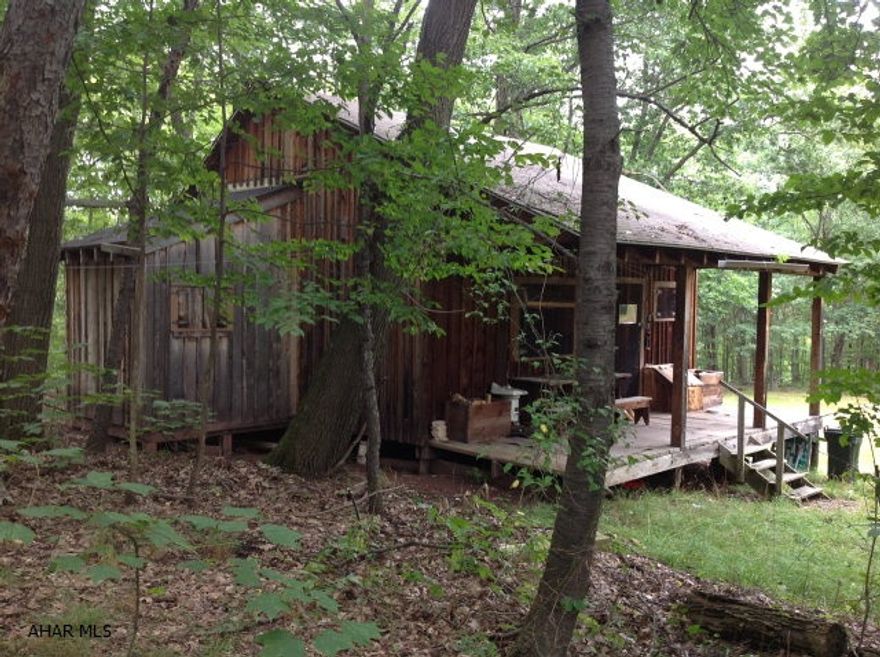 This is a outdoorsman ,hunters dream. This cabin sits nestled in beautiful mature timber including oak,cherry ,hard and soft maple,andlocust. This property is loaded with wildlife and has two springs along with a observation wooden deck over looking a pond .This is for the real hunters who are willing to not have the modern conviencees. It is ready for a Generator hook up all lights and electric is in tact.It doesn't have a well or indoor plumbing ,but does have a double duty outhouse with electric wiring run to it. It is also not to far out of town.This property has a estimated value of timber of 35000+or-. The cabin is very spacious and will sleep more then 10 hunters at a time. It does have a kitchen and Bathroom sink and would be very comfortable for even a weekend retreat or get away.