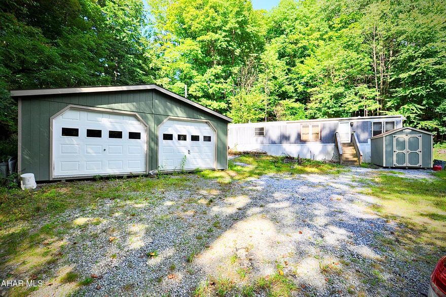 The perfect place to get away for a little while, or live full time! Situate on 1.32 very private acres, this restored mobile home is on a permanent foundation, and has so much to offer for the money. Invisible from Dudley Road, a gentle almost hidden driveway delivers you to the perfect hiding place. The home features a like new rubber roof, replacement windows, completely refinished interior with all new floors, walls and ceilings, new furnace and a/c in 2017, large rear deck, owned propane tank, spring fed water supply, 2 car detached garage, new shed, township maintained on site septic, and wonderful setting. Low taxes, secluded location, and very affordable to acquire. See it soon this will not last!