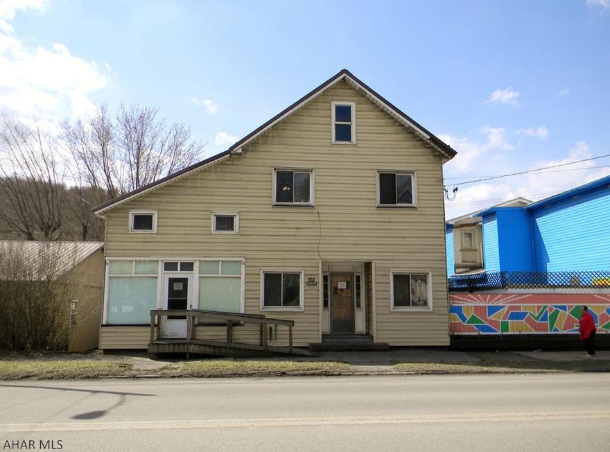 Large 3 bay garage and house on a double lot.  The house originally had a store front.  House has newer metal roof, windows and furnace.  Updated electrical panel.  Interior drywall and some parts of the ceiling will need repaired or finished. Sold AS IS.  Owner is attempting to clean out.