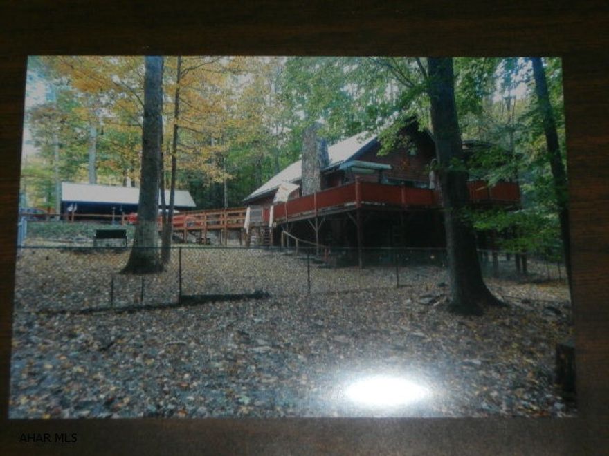 Fabulous 1.5 story home in the woods! 1st floor bedroom, large living room with vaulted ceiling, equipped kitchen. Second floor bedroom with vaulted ceiling and balcony overlooking the living room. Basement finished with large family room and fireplace with insert for pellets, bedroom  and 3/4 bath. Includes a one car garage and a two car carport with storage area attached. Great property for the $$.