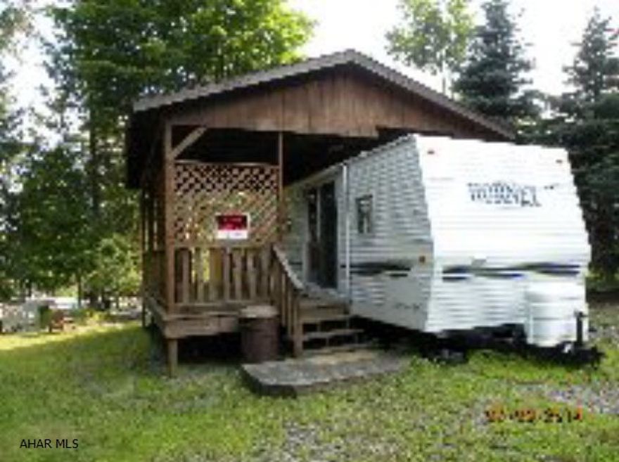 Well maintained camper w/ pavilion & shed. Nice covered deck
