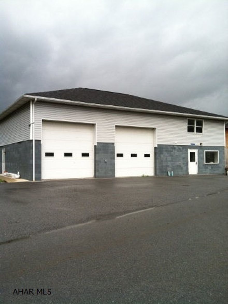 High traffic corner location and visibility off I-99 East Freedom Interchange with commercial rentals.  Rental house and 4 commercial rentals including 2 storefronts.  The building contains 4 separate suites.  Could easily be converted into storage units or even in-door boat or RV storage. Suite 1 is 14' X 37', heated, and has a rest room 7' X 7'. It also includes a 2-bay garage 32' X 37'. Suite 2 consists of two un-heated high-door bay garages and is 32' X 37'.  Suite 3 is the entire open area above the building (loft).  Suite 4 is heated office space 28' X 19', has a small kitchen area, a 7' X 7' restroom, and a storage area 7' X 4'.  There are also 2 locked storage units.  House is currently tenant occupied - rent is $600 which includes sewer.  The house was previously used commercially