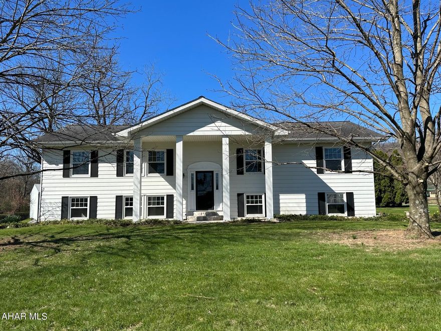 Spacious, Bi Level home and a great location! This home offers 3 large bedrooms and 2 full baths, double closet space in each bedroom, new windows and freshly painted through out, master bedroom w/separate bath, home cooling fan, lg bath w/his and her sinks and tub with custom glass doors, , large open kitchen and dining area with patio door  adjacent to the concrete balcony with black rod iron spiral steps, new cabinetry w/ granite countertops, an island, large pantry, a cook stove, luxury vinyl flooring and recess lighting. Off the kitchen a den or formal dining room. Living room overlooks to the beautiful front yard. The downstairs family room has a brick incased wood burning fireplace, a built in dinette booth, a separate country kitchen and laundry area.  Large utility/mud room with easy access to to covered patio.  Oversized 2 car garage with workbench and plenty of storage.
 Situated  on a corner lot consisting of 2 acres, with a circular paved driveway and fruit trees, apple, sour cherry, Asia pear, peach and grape vines in the yard. Only minutes from Downtown Historic Bedford.  The Juniata River is only a mile for your recreational enjoyment allowing fishing and kayaking at your convenience!  County Living at its best!