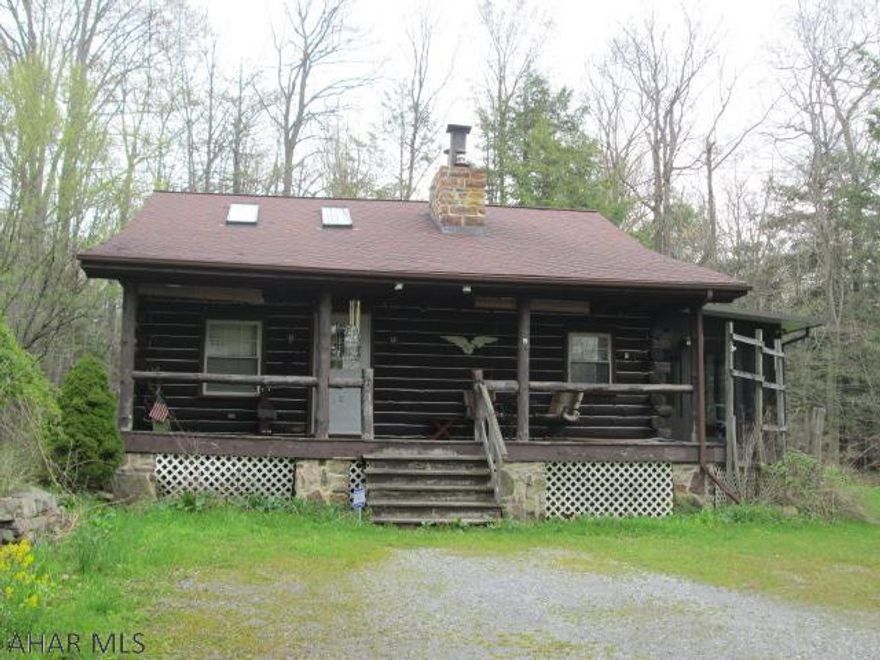 Looking for a peaceful country setting? This genuine log cabin, situated on a private 3.36 acres, could be it. Enjoy the summer evenings on the covered front porch or in colder temps, the heated sunroom will be perfect. The inside features exposed beams, giving way to a large loft area. The living room features a natural stone fireplace. First floor master bedroom with full bath. The lower level has a nice family room with an area for a wood stove. The heating system is an efficient three zone hot water. The detached two car garage has a partially finished second floor.