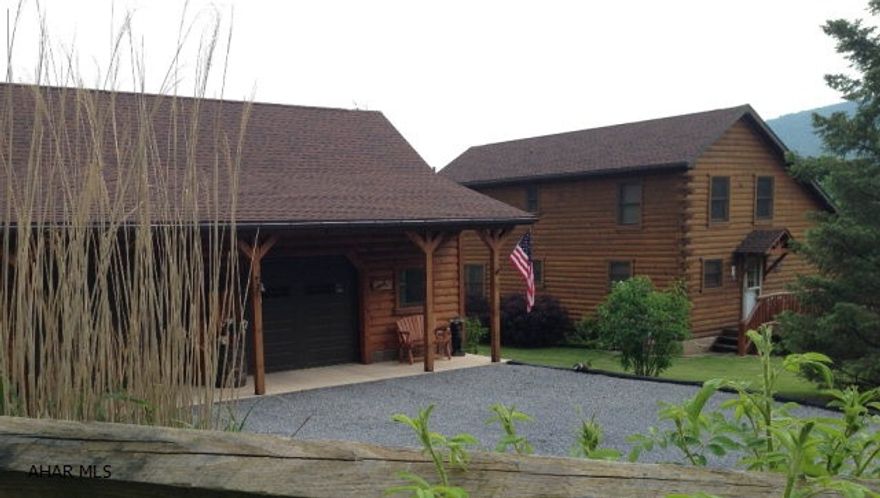 The owners of this immaculate log home have spared no expense in this stunning log home. Upon entry, a custom built hickory kitchen with new appliances opens onto the open concept two story living and dining area. Found just off this space, is a custom made covered porch that takes in terrific mountain views as well as nature. A large master suite & laundry room complete the first floor while two additional bedrooms and bathroom are found on the second floor. Small details like custom trim and woodwork, lower level kitchen, flagstone floors, huge log sided 2.5 story garage & shed add to the overall appeal. Less than 10 minutes to Chestnut Ridge School.