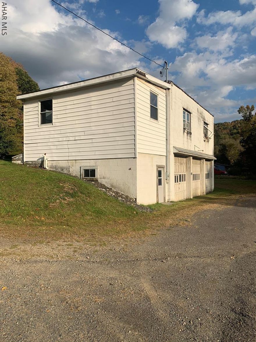 2 unit with 1 bedroom apartment and other unit used as office (contains 3 rooms and bath). Well built building includes full basement and integral garage. Heated by gas well not on subject property.  Office could be converted to apartment. Large lot in country location.