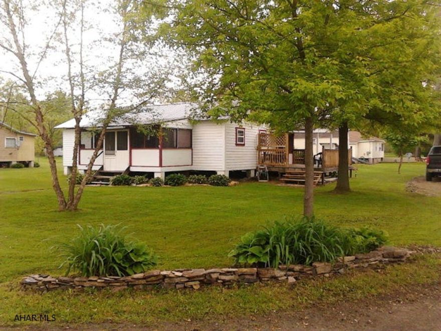 Cottage style house in camp Sunshine.  New addition makes for a nice sized master bedroom.  Large great room with open beam and rough sawn lumber.  Front and rear enclosed porches.  Side deck and detached storage buildings.  Low maintenance, public sewer, level lot and access to Dunnings Creek.