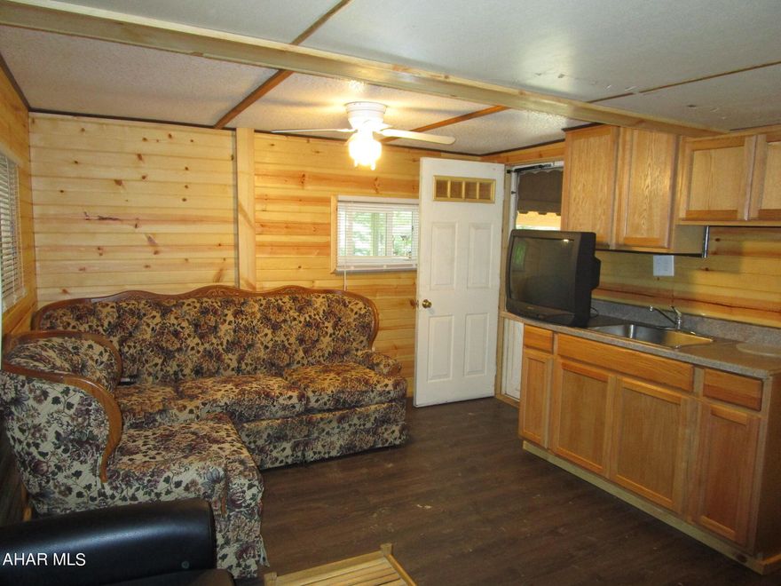 Camper / cabin - This cozy camper has been expanded in all the right placed.  An addition was added to enlarge the kitchen  / living area so you can gather inside on rainy days and nights.  The bathroom was remodeled with a full size shower and house fixtures.  Private backyard against the woods.  Nice size shed.  Low maintenance.