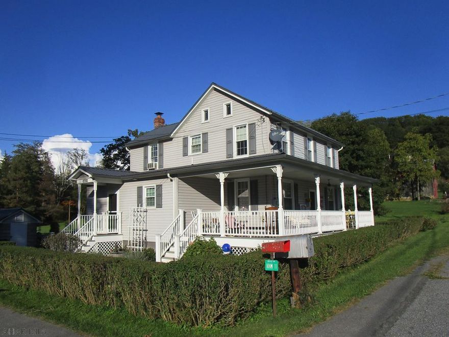Superb street appeal!  Stream frontage. Kitchen update 2008. Add.:1st flr. bath & entry/laund.rm., vinyl siding, ext.shut., metal roof/s.birds, gutters/dspouts.,ext.doors + storms, wrap'round  & side porches w/ vinyl rail./posts new in past 5+-yrs. Ideal garage w/ int.stairs to 2nd flr.+wd./coal furn., wall-mount prop.gas heat.,wd.rm. & stg.anx.  A 2-c.carport, smoke house, garden shed, chick.coop. Orig. house replace.windows-2004. Garage & all outbldg's.newer metal roofs except. chick. coop.  Xfinity. B.R.E.C., 2 wells (1 in use). "Eco-Flow" septic/mound syst. installed 2001-'02'+-(needs inspected periodically / moss has to be replaced periodically.)  Base.water proof syst.-2 s.pumps.   Ages, SF, taxes, site area approx.-NO WARRANTIES.