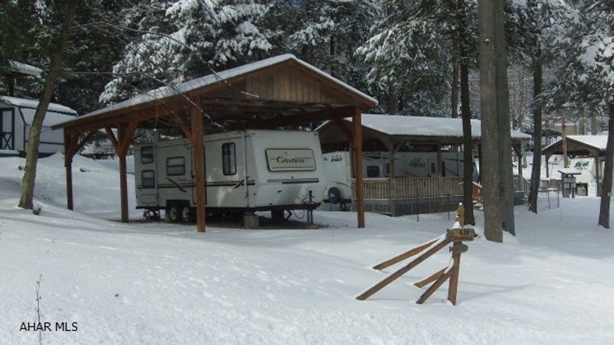 Terrific value: large corner lot, camper protected under pavilion and shed with contents for the price of just the lot.  Bedroom with double bed and separate area with bunks.  The camper is already here so come ready to relax and enjoy.  Located in gated Glendale Yearound in a wooded setting.  Community pool, tennis/basketball and volleyball courts, playgrounds, and horseshoes.  Lot is not far from the dog park and ball field.  Community is adjacent to Prince Gallitzin State Park / Glendale Lake and only six miles from Rock Run ATV Park so bring your quads.  A/C unit is on the roof. Camper has smoke and carbon monoxide detectors.  Pavilion has a shingled roof.