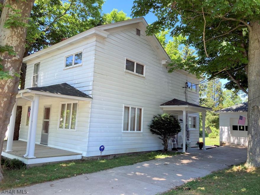 Quiet small-town living found here! Enjoy the tree-lined street and peaceful feel of this location. Packed with curb-appeal on a pretty half-acre corner lot, this home beckons you in. Step inside the side entry and chuckle as you check out the cute retro eat-in kitchen. You're sure to love the corner windows with light streaming into the dining section! Enter the large living room and prepare to be impressed by the size, hardwood floors, fireplace and multiple windows. Other areas to not miss on floor one include the laundry room, half bath and enclosed back porch just waiting to be finished into a big mudroom. Once upstairs, you will find three well-sized bedrooms and a full bath with large vanity and newer fixtures. The "owner's bedroom" has his 'n her closets with one being a walk-in. T