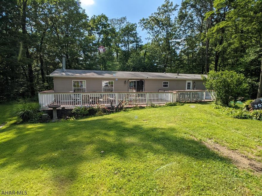 Huge 28x80 double-wide on nearly 1 acre private lot. Open floor plan features kitchen with center island and large dining area plus adjoining great room w/ wood burning FP. First floor also includes formal dining room, laundry room. 4 bedrooms, 3 full baths including huge ensuite with hot tub, stand up shower, double sinks and walk-in closet. Large from deck and fenced rear yard. 2 car detached garage and more in a private, peaceful setting. Check it out!