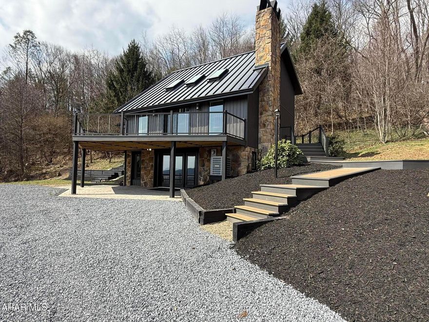 Mountain Masterpiece | Bedford/Altoona Corridor

This is not a flip. This is a complete rebuild executed with an uncompromising commitment to quality and the result is breathtaking.

Nestled into a private hillside on 4.35 acres, this modern mountain retreat commands sweeping views of the Allegheny countryside. Imagine morning coffee as the sun rises over the ridgeline, or evenings watching golden light melt across the valley. This is a place where slowing down feels effortless.

The curb appeal is serious. A dramatic 26-gauge snap-lock standing seam metal roof in deep charcoal tops an exterior of rich stacked stone and board and batten siding, the definition of modern mountain done right. Professionally designed hardscaping, beautifully laid paver walkways, and meticulously landscaped grounds make every inch of the exterior intentional.

The expansive wraparound deck is a true showstopper, accessible from both the kitchen and living room, framed by sleek black railings with panoramic mountain views in every direction. 

Inside, soaring vaulted ceilings with dark shiplap and skylights bathe the great room in natural light. Premium luxury vinyl tile flows throughout the main living areas, delivering the warmth and beauty of hardwood with superior durability, complemented by plush carpet in the bedrooms. A stunning stone fireplace anchors the living room, and on a crisp mountain evening there is simply nothing better.

The kitchen impresses with white cabinetry, black hardware, subway tile backsplash, stainless appliances, a gorgeous wood island with turned legs, and quartz countertops. All bathrooms are finished in quartz as well. Two upper bedrooms share a beautifully appointed Jack and Jill bathroom, each with their own private access, ideal for family or guests.

The owner spared absolutely no expense on comfort and efficiency. A top-of-the-line, high-efficiency HVAC system ensures perfect climate control year-round, while the highest quality doors and windows were selected throughout, providing superior insulation, stunning aesthetics, and the kind of craftsmanship that sets this home apart from anything else in the market.

The 4-car detached garage with hydraulic lift is a car enthusiast's dream. Approximately 2.5 of the 4.35 acres is tillable, perfect for a garden, hobby farm, or wide open green space. Trails wind throughout the property and I-99 is easily accessible, making this the perfect balance of seclusion and convenience between Bedford and Altoona.

Whether you're seeking a primary residence, vacation retreat, or investment property, this one checks every box. For the savvy investor, the property sits on 5 separate tax identification parcels, offering exceptional flexibility and future subdivision potential, while currently functioning as one cohesive, stunning mountain estate.

Properties like this don't come along often. Schedule your private showing today.