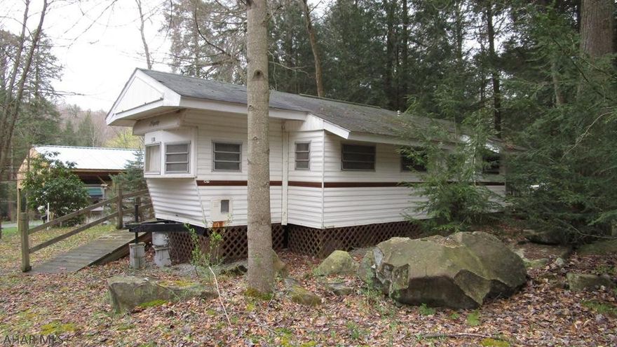 Roomy unit with sliding glass door onto covered deck. Ramp for handicap accessible. Previous owner did some renovation work on the floor and ceiling.  Adjacent property is also for sale which makes a great space for family or friends to get away together.  Title is retired.