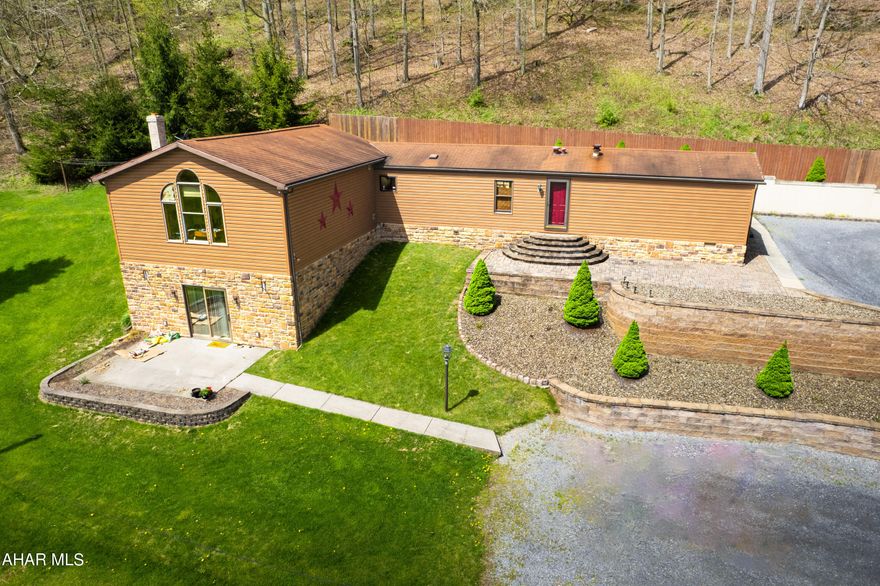 Unique Countryside Home/Retreat with breathtaking views of the mountains nestled on 13.25 mostly wooded acreage.  The stone and vinyl exterior opens from the 16ft patio into a spacious gathering room, exposed beams, a brick wood burning fire place and ceramic tile flooring.  The second level Great room is complete with Atrium windows, pellet stove, LP flooring, recess lighting. The kitchen cabinetry is oak, the refrigerator is recessed which  adds more space to the kitchen. The trailer is dry wall throughout. Step out on to a 70 ft private rear patio, as you can enjoy the mountain views. The  2 storage sheds 10x20 and 10x12 provide ample space for outdoor equipment and hobbies accompanied with electric! Explore the outdoors with several ATV trails cut for easy access throughout the property!  Local amenities near,  Shawnee State Park, Blue Knob Ski Resort, Rocky Gap State Park 
Set up your tour today !