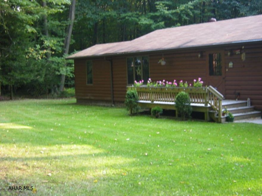 Easy Living in this Log Sided Home.  Open floor plan, beamed ceilings, Wood Burner in Living Room provides whole house heat.  Electric heat with thermostats in each room.  Front Porch and Large Covered Back Porch and Deck all have composite boards for low maintenance.  Huge two car garage and large work room and room for riding mower attached.  Two sheds included.  Home built on 1.4 acres with Park like setting in back yard.  Additional 2.5 acres that leads to State Game Lands (Hunters Dream)