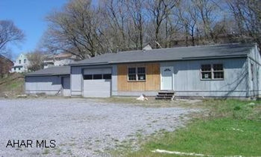 One story building that was built and used by a contractor for his business. The house or office section is 896 sq' and 80% finished, the 1 car attached garage is complete. The 32x28 workshop is complete. The exterior needs finishing work and more. More...electric needs connected from the street to the building, sewer and water is at the street but needs taps and connections. Zoned R-3. Great building for someone that would live in the house and have workshop, garage. There was a variance but it expired and a new request will need to be approved.