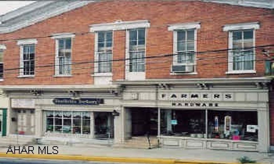 Historic 2 story brick building with 2 story fronts. Currently used known as Farmer's Hardware. Upstairs with large meeting rooms, kitchen and restrooms.  Second storefront is rented to a health/herb store. Upstairs rented to a church group.