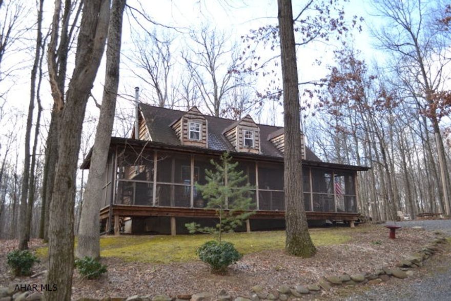 Quality and serenity are put first in this wonderful wooded retreat.  Located on 22.225 wooded acres, this home offers very spacious rooms, tongue and groove hemlock flooring, fireplace and hearth built from on site stone, hand hewn stairwell and railings, gourmet kitchen with cork flooring, claw foot tub, custom cabinetry, and much more.  Make no sacrifices when you come to the woods though, house includes, heatpump w/ central air, and oil backup.  40+ ft screened in porch, large outdoor fire ring area, outdoor shower, and complete additional cabin.  Cabin was built before main house, currently used for storage but could easily be finished into a guest house.  2 bay carport, large front porch on separate cabin.  Mature trees, and wildlife is abundant.  Don't miss your chance!  Call today!